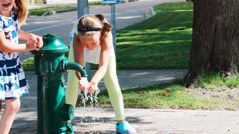 Kids playing by a water hydrant with clean and safe water