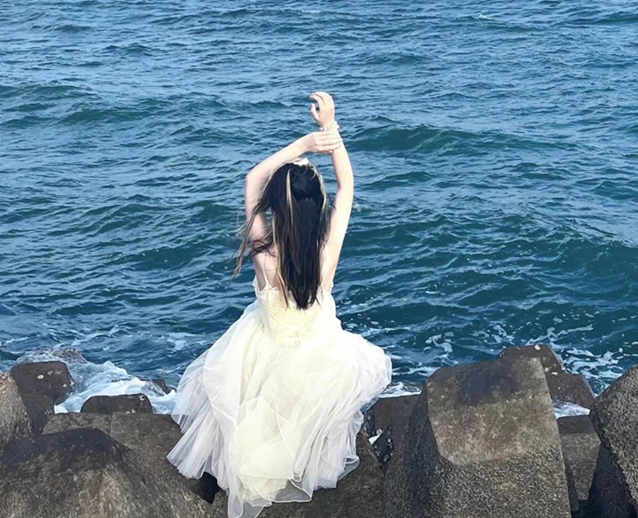 Girl sitting on the edge of a lake