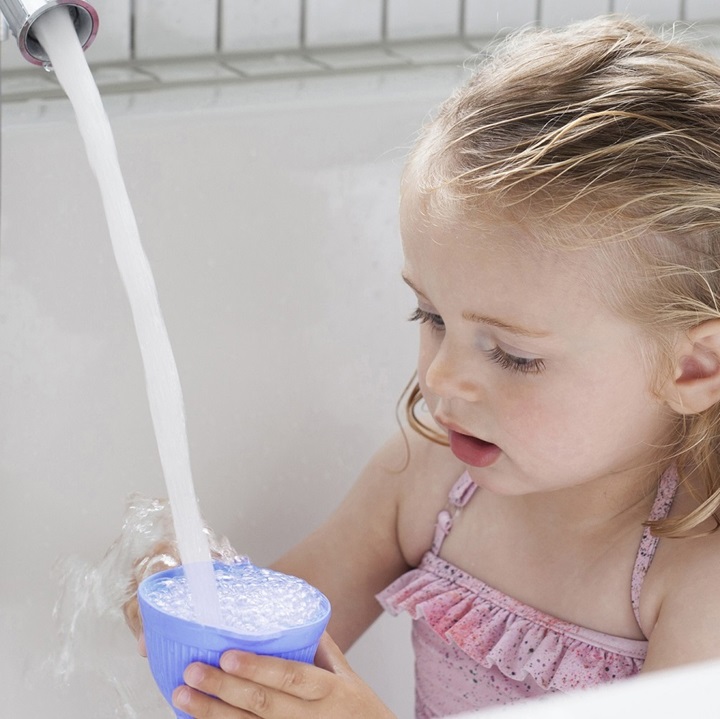 A girl and clean water flowing out the tap